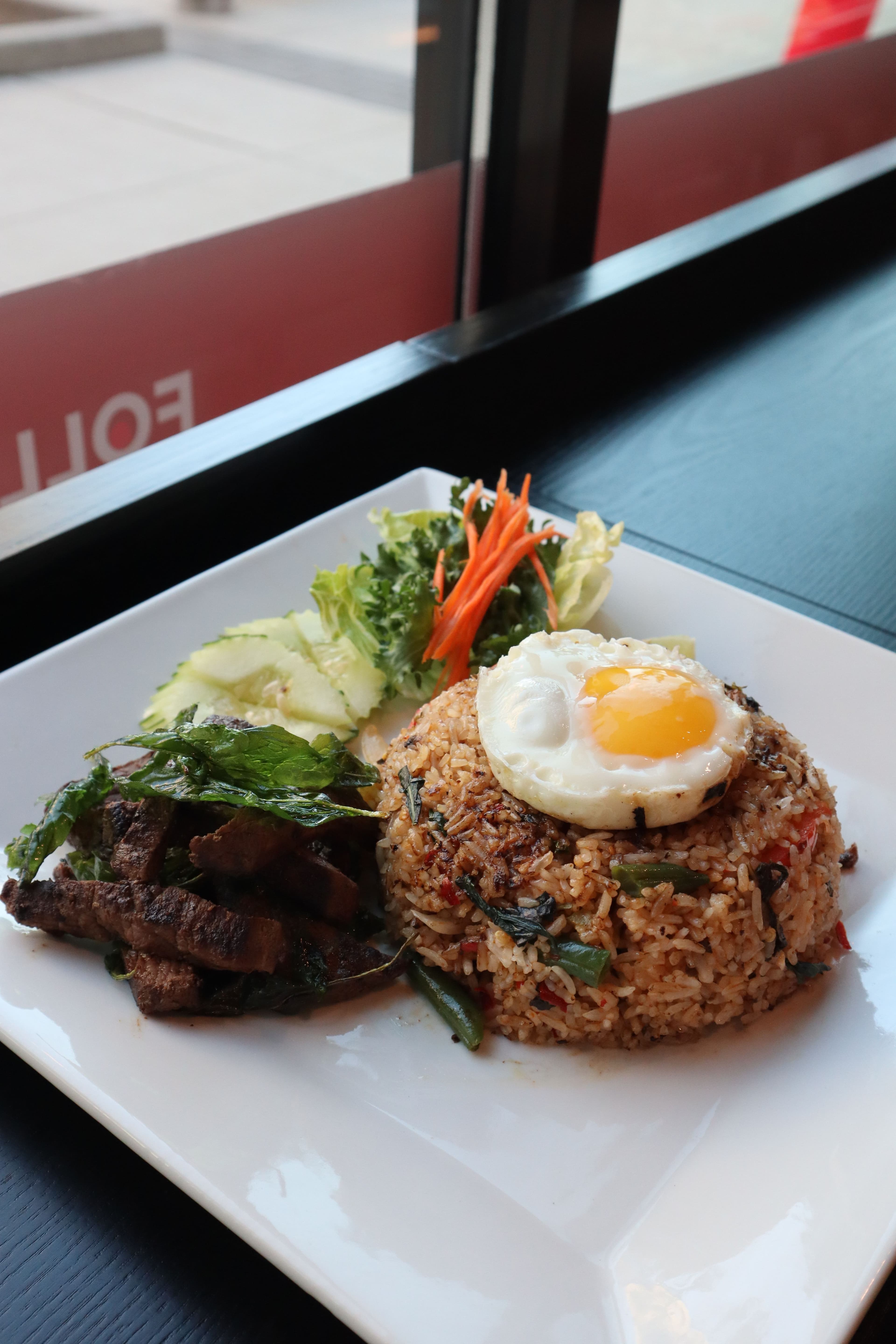 Basil fried rice with grilled beef and a fried egg